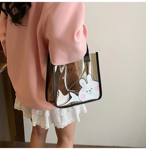 Dettaglio borsa in PVC trasparente marrone con coniglio bianco e manici neri resistenti