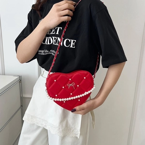 Red heart-shaped quilted crossbody bag with pearl trim and elegant chain strap for women