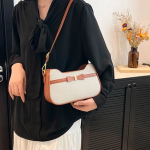 Borsa a spalla minimalista a orecchie di gatto in tela beige con finiture marroni su modella