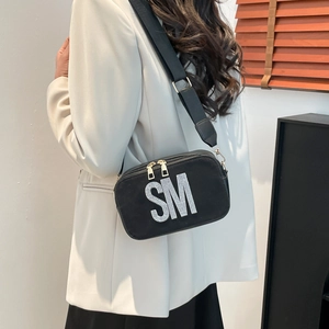 Black crossbody bag with rhinestone SM letters and adjustable wide strap on model