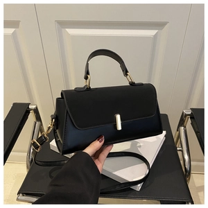 Detail of black leather small square bag with gold twist lock and detachable strap