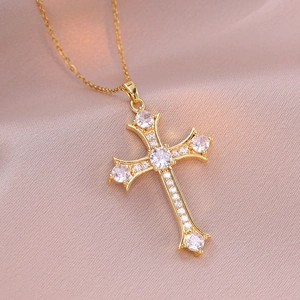 Collier croix dorée rétro punk avec zircons transparents sur tissu en soie rose