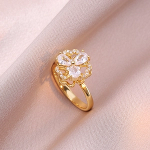 Detail eines Goldrings mit Zirkonia-Blütenblättern und filigranem Besatz auf Seide