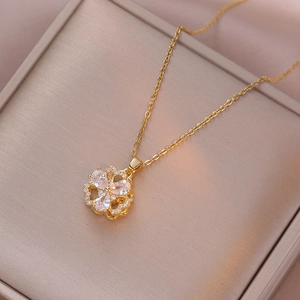 Makroansicht goldener Blumenanhänger mit Zirkonia-Steinen auf einer Schmuckbox