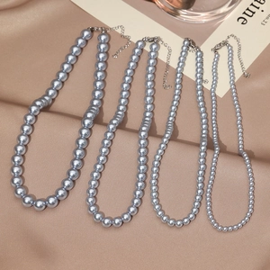 French vintage grey pearl necklaces in four sizes on elegant beige silk fabric