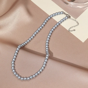 Detail of grey pearl necklace with adjustable silver lobster clasp on satin background