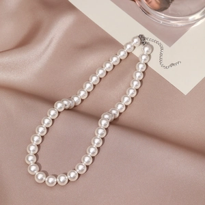 Detail of white round pearls on silk with an adjustable silver lobster clasp necklace