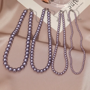 Elegant lavender pearl necklaces with silver lobster clasp on champagne satin background
