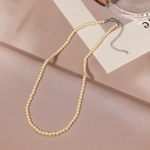 Detail of elegant cream pearl necklace with adjustable silver lobster clasp and chain