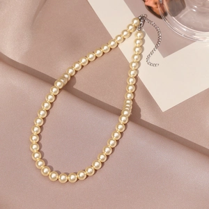 Detail view of round creamy white pearls with high-quality silver lobster clasp and chain
