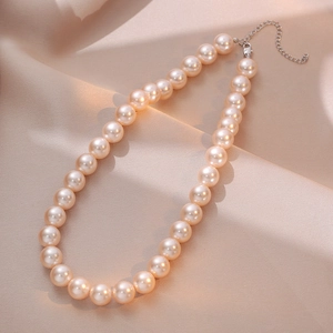Elegant champagne pearl necklace on satin fabric with adjustable lobster clasp and chain