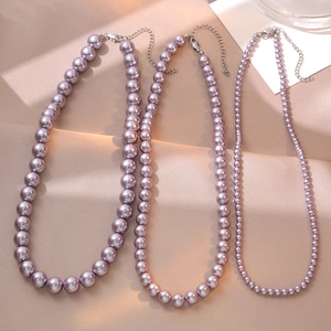 Three sizes of lavender pearl necklaces with silver lobster clasps on purple silk fabric