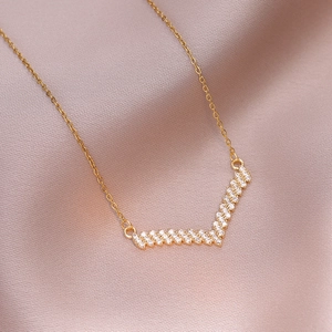 Élégant collier en V doré en acier titane avec zircons micro-pave sur tissu satin