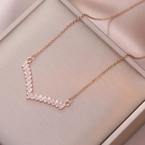Collier en V or rose avec cristaux micropave sur un fond élégant en satin soyeux