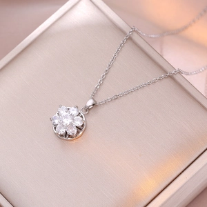 Macro shot of a silver flower necklace featuring sparkling cubic zirconia on a gift box