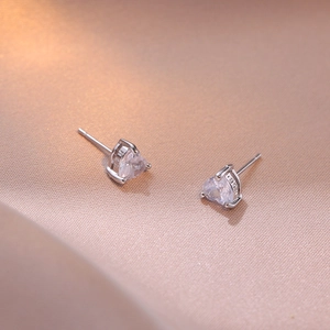 S925 sterling silver heart-shaped zircon stud earrings on a warm silk background