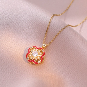 Golden rotating four-leaf clover pendant necklace with red enamel and zircon on silk