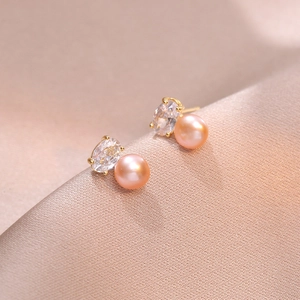 Elegant gold earrings featuring pink freshwater pearls and sparkling oval zircon stones