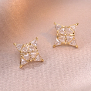 Élégantes boucles d'oreilles étoile dorée à quatre branches avec incrustation de zircon