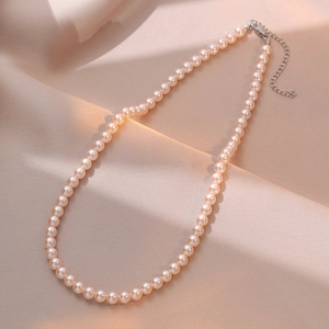 French style pearl necklace with crystal beads on elegant champagne silk background