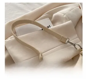 Close-up of soft beige leather handle and metal hardware on a vintage hobo shoulder bag