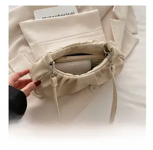 Close-up of beige pleated cloud bag interior showing large storage space and zip closure