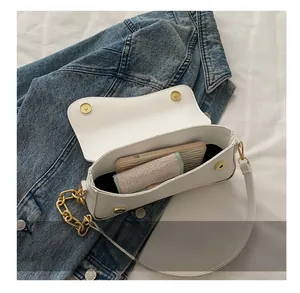 Detailed interior capacity showing white leather bag holding a smartphone and wallet