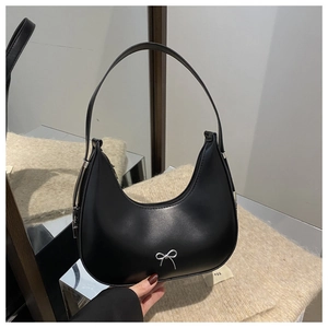Detailed shot of a black hobo bag with a silver metal bow accent and zipper closure