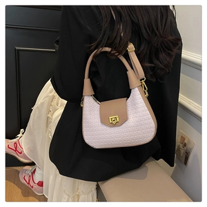 Detail of woven texture on cream and brown shoulder bag with gold metallic clasp