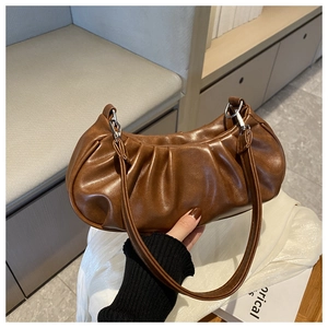 Gros plan détaillé de la texture plissée et du fermoir argenté d'un sac hobo brun