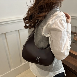 Minimalist dark brown half-moon hobo bag with silver bow detail and shoulder strap