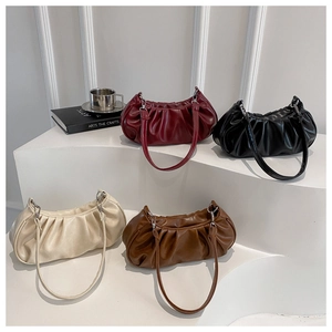 Detail view of ruched crescent underarm bags in burgundy, black, cream, and brown colors