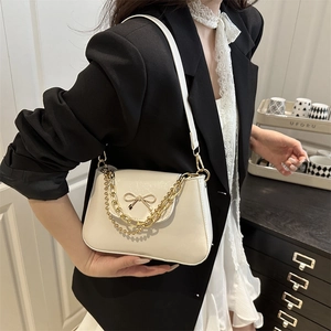 Elegant cream shoulder bag with golden bow clasp and chain strap for women