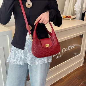 Deep red woven moon crescent bag with golden twist lock and adjustable crossbody strap