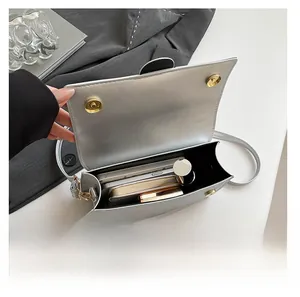 Silberne Metallic-Handtasche zeigt Innenraum für Smartphone und Geldbörse