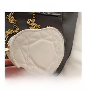 Detail of white heart-shaped quilted leather bag with elegant gold chain strap texture