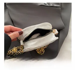 Detail view showing white quilted heart bag interior with chain and zipper closure