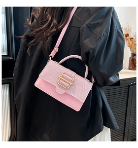 Detailansicht der rosa Pailletten-Lederhandtasche mit goldener Metallschnalle am Trageriemen