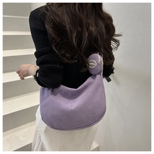 Detaillierte Textur der lila Cord-Halbmondtasche mit einer runden Mini-Tasche