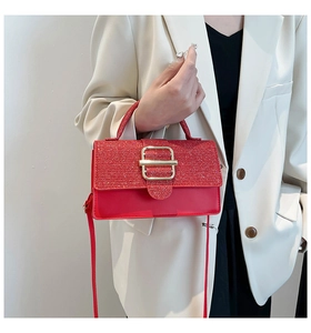 Détail du sac rouge avec rabat à paillettes et boucle métallique dorée élégante