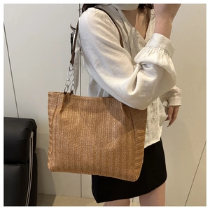Detail der gewebten Stroh-Tasche mit V-Muster-Struktur und Ketten-Leder-Schultergurt