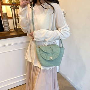 Light green woven crossbody bag with pearl closure for elegant beach and casual wear
