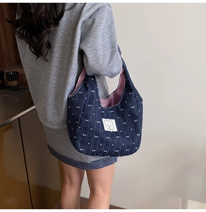 Detail der Jeans-Handtasche mit weißen Schleifen, Herz-Prints und gestreiftem Futter