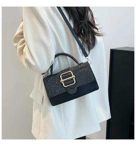Detail der schwarzen Handtasche mit Glitzerklappe, Goldschließe und Model im Blazer
