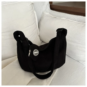 Close-up of black corduroy hobo bag with a round coin purse and wide shoulder strap