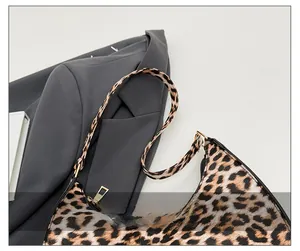 Detail view of the comfortable shoulder strap and trendy leopard print saddle bag