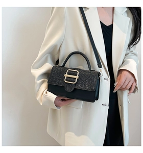 Détail du sac bandoulière pailleté noir avec boucle dorée et bandoulière réglable