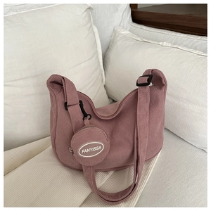 Detail of dusty pink corduroy hobo bag and matching round coin purse on bed