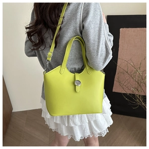 Detailed view of neon green tote bag featuring silver round buckle and adjustable strap