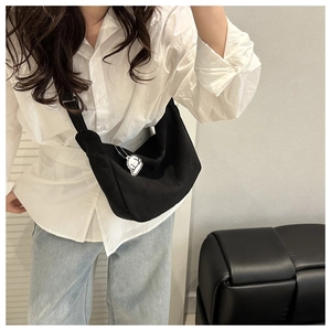 Detailed view of black corduroy dumpling bag with adjustable strap and cloud charm